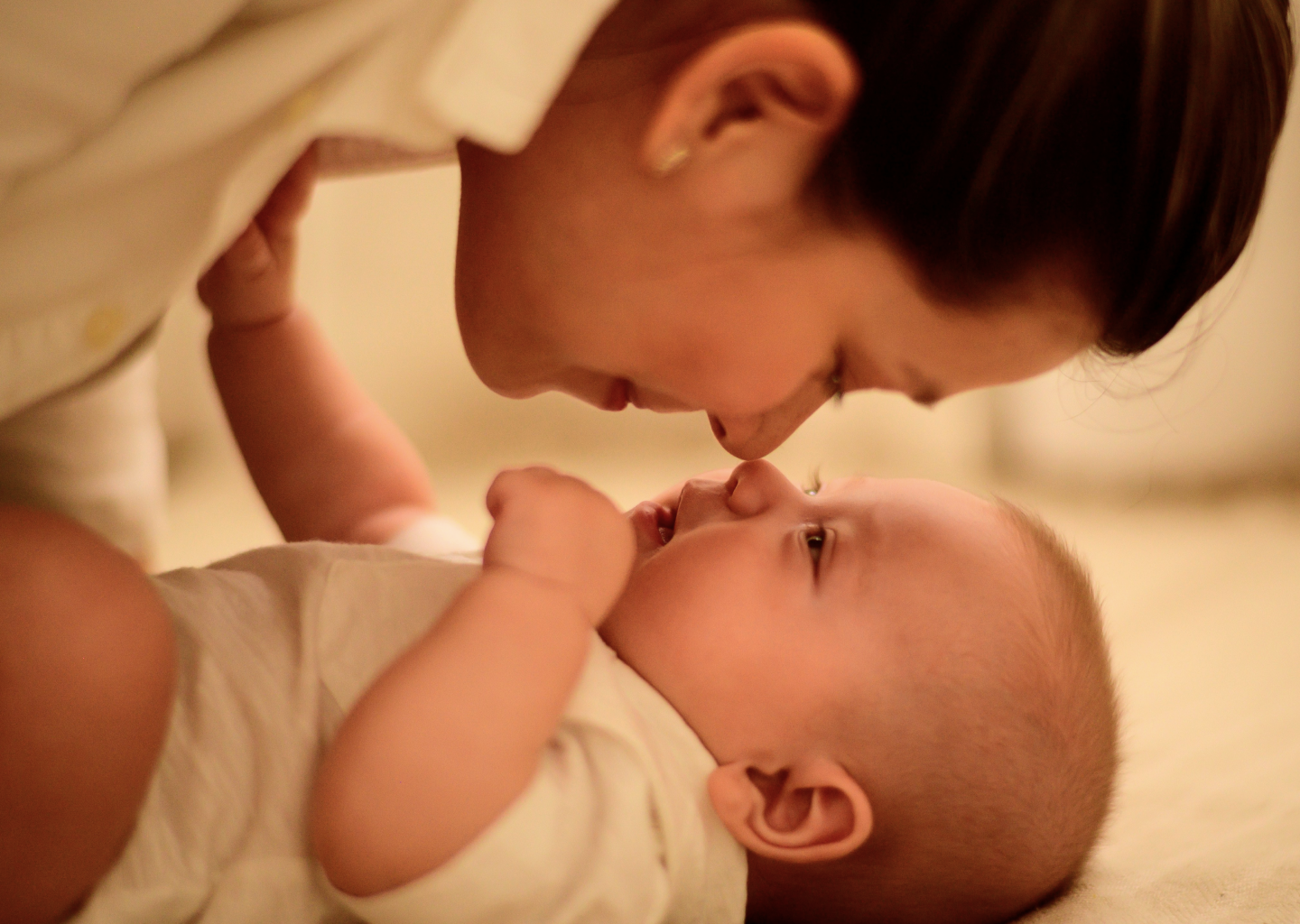 Mom kissing newborn on changing table — safe diapering with HIRO Diapers
