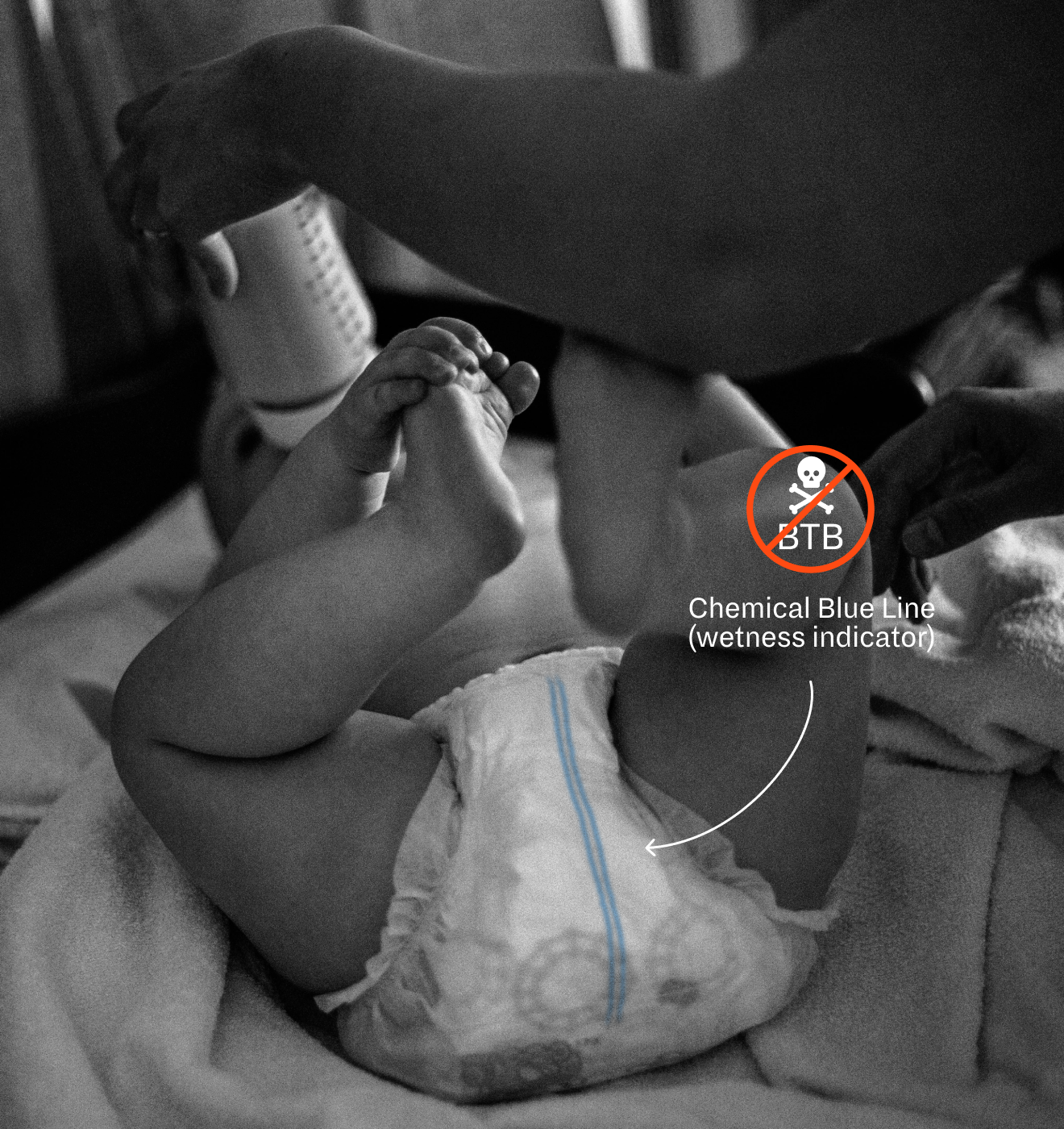 Parent changing a baby’s diaper showing a faint blue line — article about wetness indicators and baby safety.